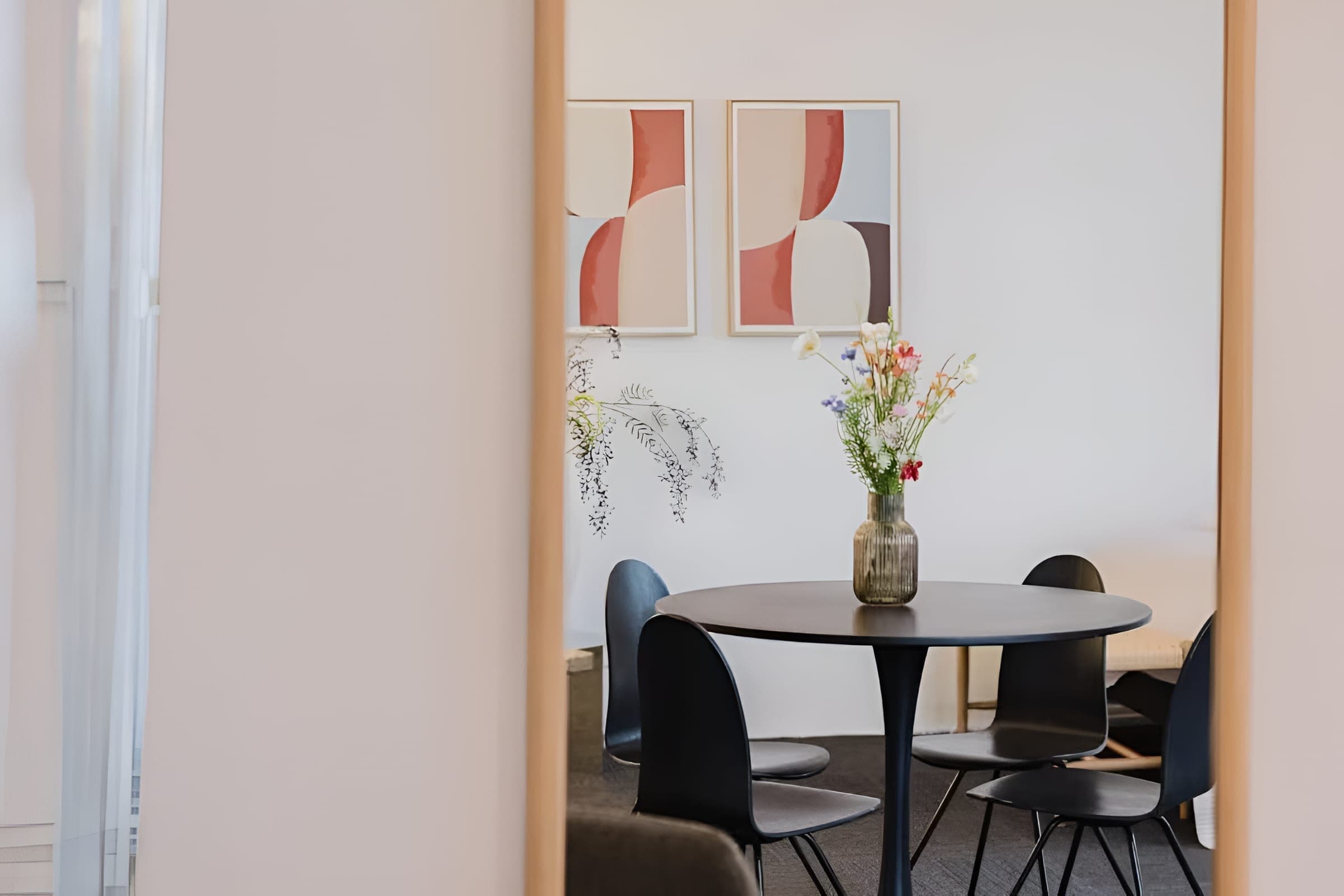 Dining table with flowers reflected in a mirror
